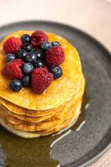 Pancakes with berries and maple syrup stock photo