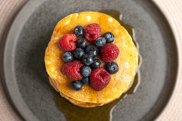 Pancakes with berries and maple syrup stock photo