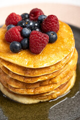 Pancakes with berries and maple syrup stock photo