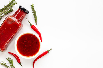 Bottle of spicy sauce tabasco with red hot chili pepper, top view