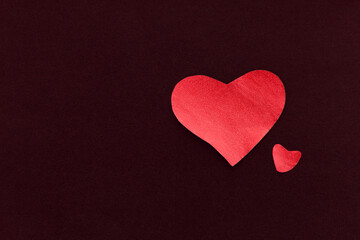 Two red heart on a black background, made of paper, romantic and festive beautiful symbol love