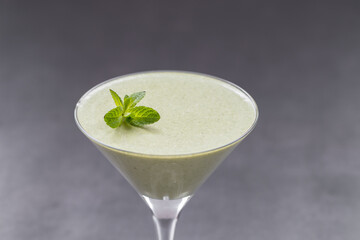 Mint cream jelly, Panna Cotta in a martini glass. Dark gray background. Close up