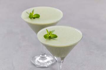 Vegan mint cream jelly, Panna Cotta in a martini glass. Light gray background