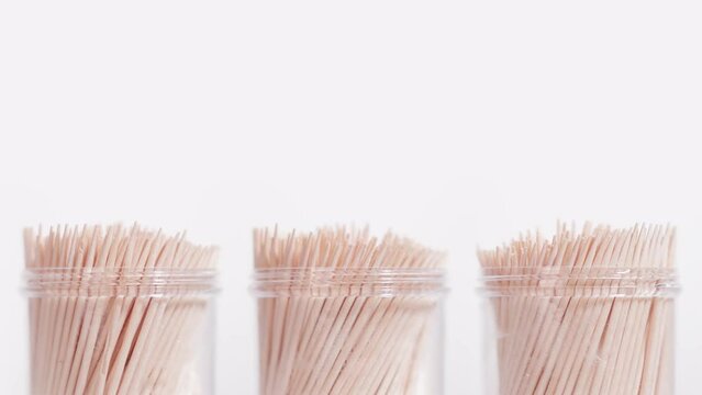 Three toothpick containers rotate on a white background