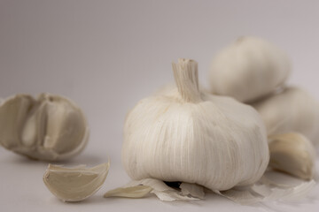 Weiße Knoblauchknolle ganz, halbiert und herausgelöste Zehe in nostalgischem Look