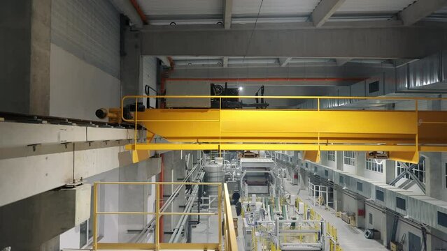 Industrial lifting crane at the enterprise that travels on rails. The crane moves without a load