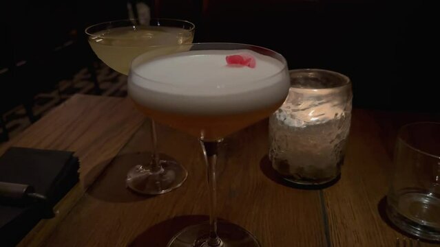 A cocktail with a flower on a table in a night clu
