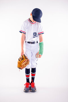 Male youth baseball player standing with his broken arm in a cast