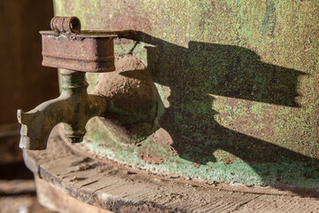 Rusty faucet detail from old olive oil drum