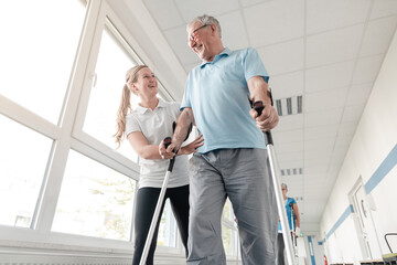 Seniors in rehabilitation learning how to walk with crutches after having had an injury