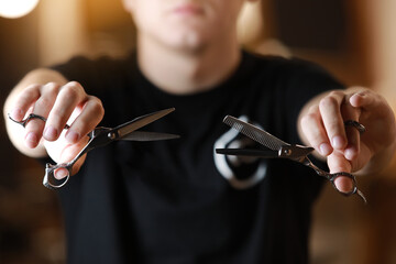 Barbershop. Unrecognisable hairdresser is holding two type of scissors. Barber professional tools. Male haircut, fashion. Hair salon, haircut and shaving background. Small business. Selective focus