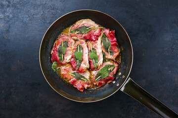 Traditional Italian fried pork saltimbocca alla Romana with Parma ham and sage leaves served as top...