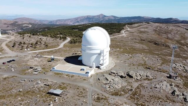 Drone aerial view of Calar Alto Observatory at the snowy mountain top in Almeria, Andalusia, Spain. Observatory domes skyshed.