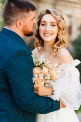 a bride in a delicate dress with a bouquet with the groom in the park