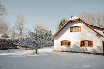 beautiful farmhouse in Germany, in winter. White old farmhouse covered in snow. House with a large...