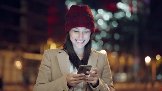 Video of young woman tourist laughing and taking selfie photo with mobile phone in the city at night