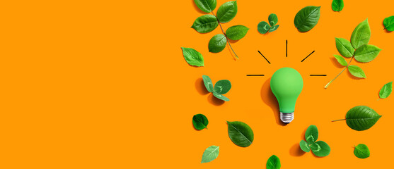 Green light bulb with green leaves - Flat lay