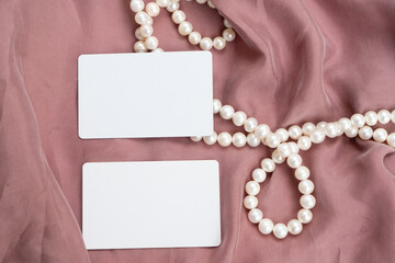 Fototapeta na wymiar Pearl jewellery and pink silk styled stock scene, for wedding invitation, product showcase or styled presentation with copy space, top view