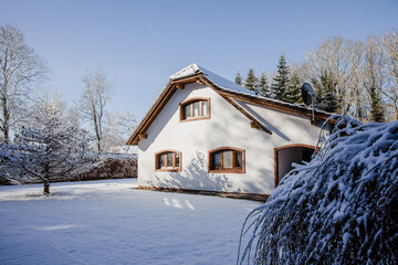 beautiful farmhouse in Germany, in winter. White old farmhouse covered in snow. House with a large garden.