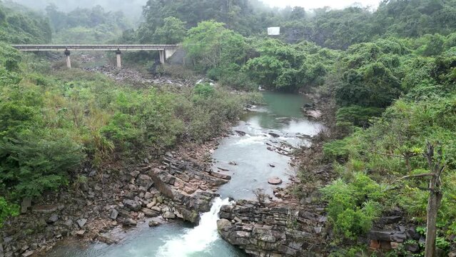 Small river with bridge and rocks in Vietnam, Aerial
Small waterfall in the mist, Drone view 2023

