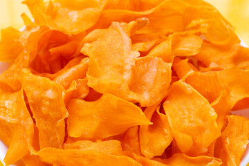 Sweet potato chips on yellow background.