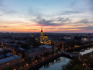 Fototapeta na wymiar Holy Annunciation Cathedral with lights illumination and evening sunset vivid cloudscape. Aerial Kharkiv city orthodox church in downtown, Ukraine