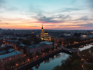 Fototapeta na wymiar Aerial Holy Annunciation Cathedral with lights illumination and sunset scenic cloudscape. Kharkiv city orthodox church in downtown, Ukraine
