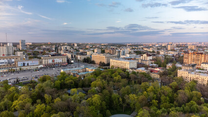 Fototapeta na wymiar Aerial view on Svobody Square and historic buildings from city park with sunset light. Kharkiv, Ukraine in spring