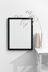 Blank vertical photo frame mockup on white wall with copy space