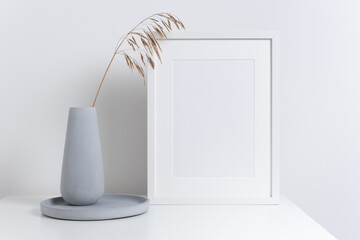Blank vertical frame mockup in white interior with decor
