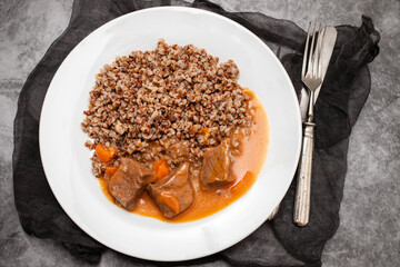 Boiled buckwheat with meat and sauce on white dish