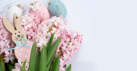 Easter scene with fresh pink hyacinth flowers and Easter Bunny with eggs, festive banner