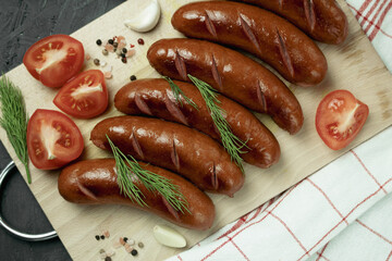 Grilled sausage with the addition of herbs and vegetables on the grill plate, outdoors. Grilling food, bbq, barbecue