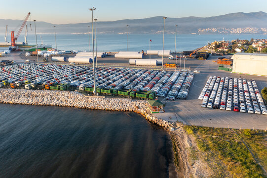 New assorted cars lined up in the port waiting to be loaded on the ro-ro (Roll on Roll off) vehicle car carrier ship. Aerial drone photo