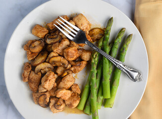season chicken bites   top with  mushrooms with asparagu