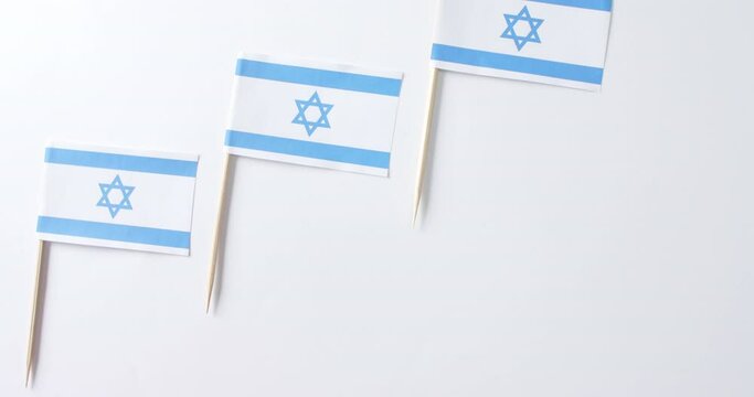 Close up of three flags of israel lying on white background with copy space