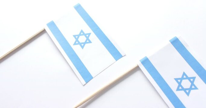 Close up of three flags of israel lying on white background