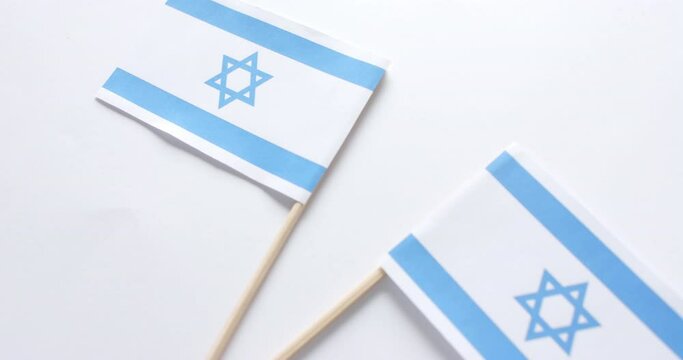 Close up of two flags of israel lying on white background