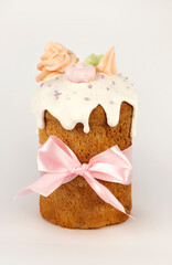 Traditional Easter glazed panettone with pink bow on white background.