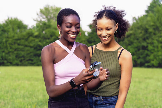 Two young women of different ethnicities having fun outdoors in a park