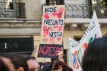 A woman holds up a poster with a message against violence against women