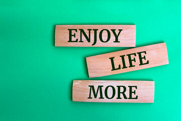Wooden blocks with words 'Enjoy Life More'.