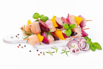 Skewers with pieces of raw meat.Top view.Chicken Skewers breast fillet meat.Raw chicken meat skewers with vegetables,plums,yellow pepper,onions,with spices,herbs white background.Uncooked meat skewer.