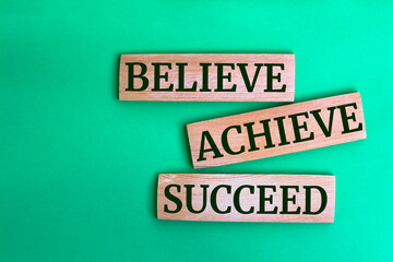 Wooden blocks with words 'BELIEVE ACHIEVE SUCCEED'.