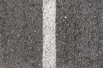 Fototapeta premium Background gray dry asphalt top view with a white marking line in the center
