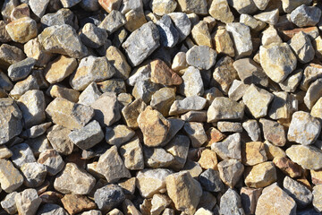 Gravel texture. Pebble stone background. Light grey closeup small rocks. Top view