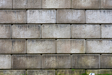 An abstract image of a retaining wall constructed from large rectangular concrete blocks. 