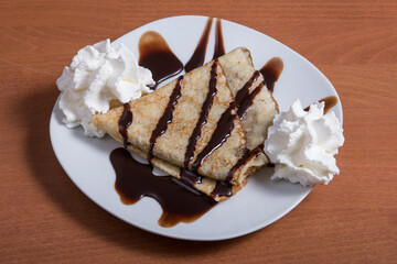 Chocolate crepe with sugar and whipped cream