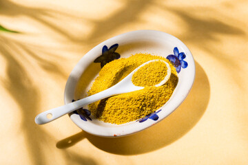 Yellow Comfort: Curry in Ceramic Bowl and Spoon with natural shadows, top view