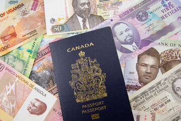 An Canadian passport on a background of African currency